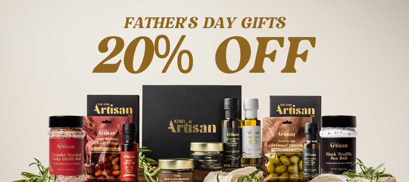 A Father's Day gift bundle from Daily Artisan, featuring an assortment of gourmet products including olive oil, black truffle, artichokes, and spices, arranged with decorative herbs against a beige background with a '20% OFF' promotional banner.