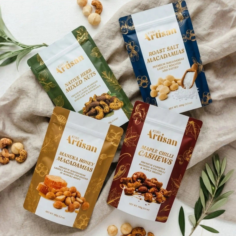 Assorted packages of Artisan nuts on a textured surface with greenery.